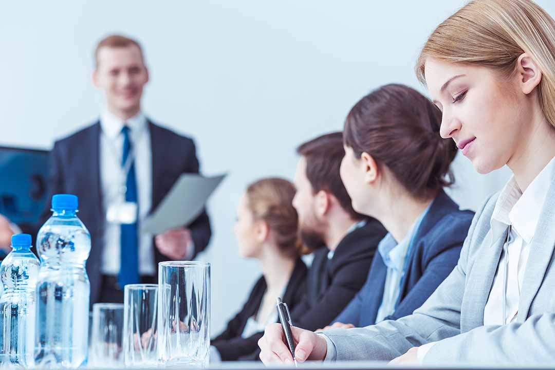 Elegant business lawyers writing during company board meeting