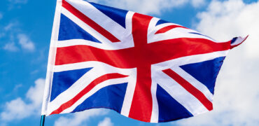 United Kingdom Flag waving on wind in blue sky